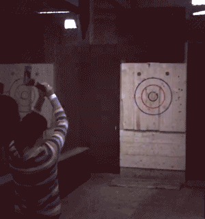 A gif of someone throwing an axe at a target.