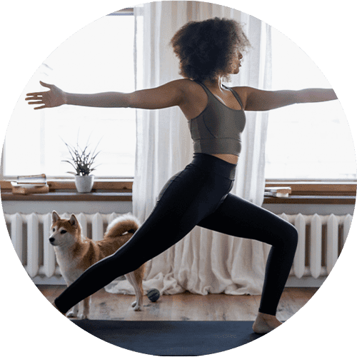 A woman and her dog are practicing yoga.