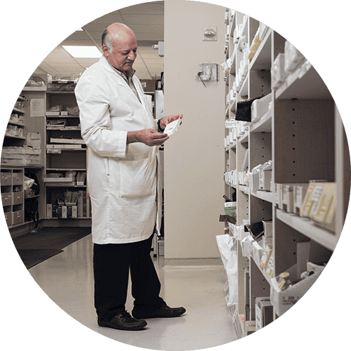 veterinarian standing in the inventory room looking at a prescription package