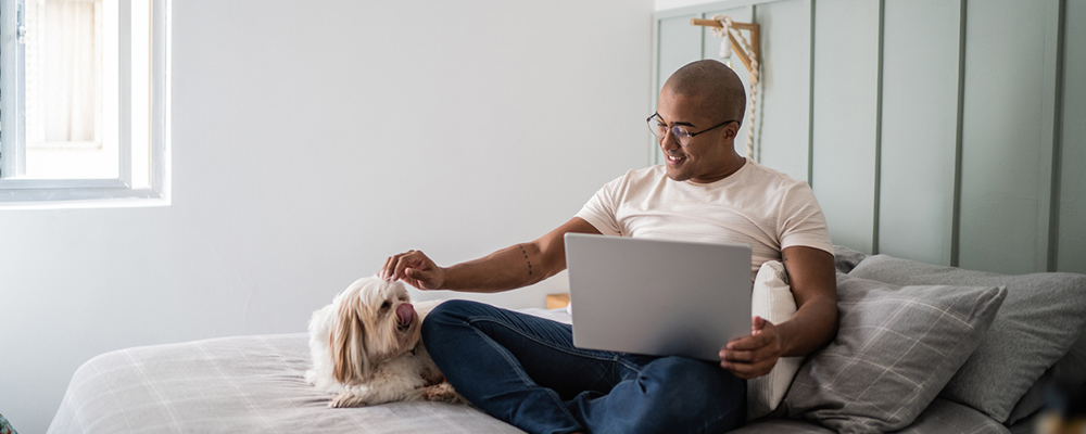 Pet owner watching Veteos On-Demand video with dog